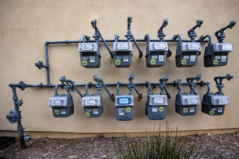 Utilities neat installation of gas meters mounted on an exterior wall in an urban setting.