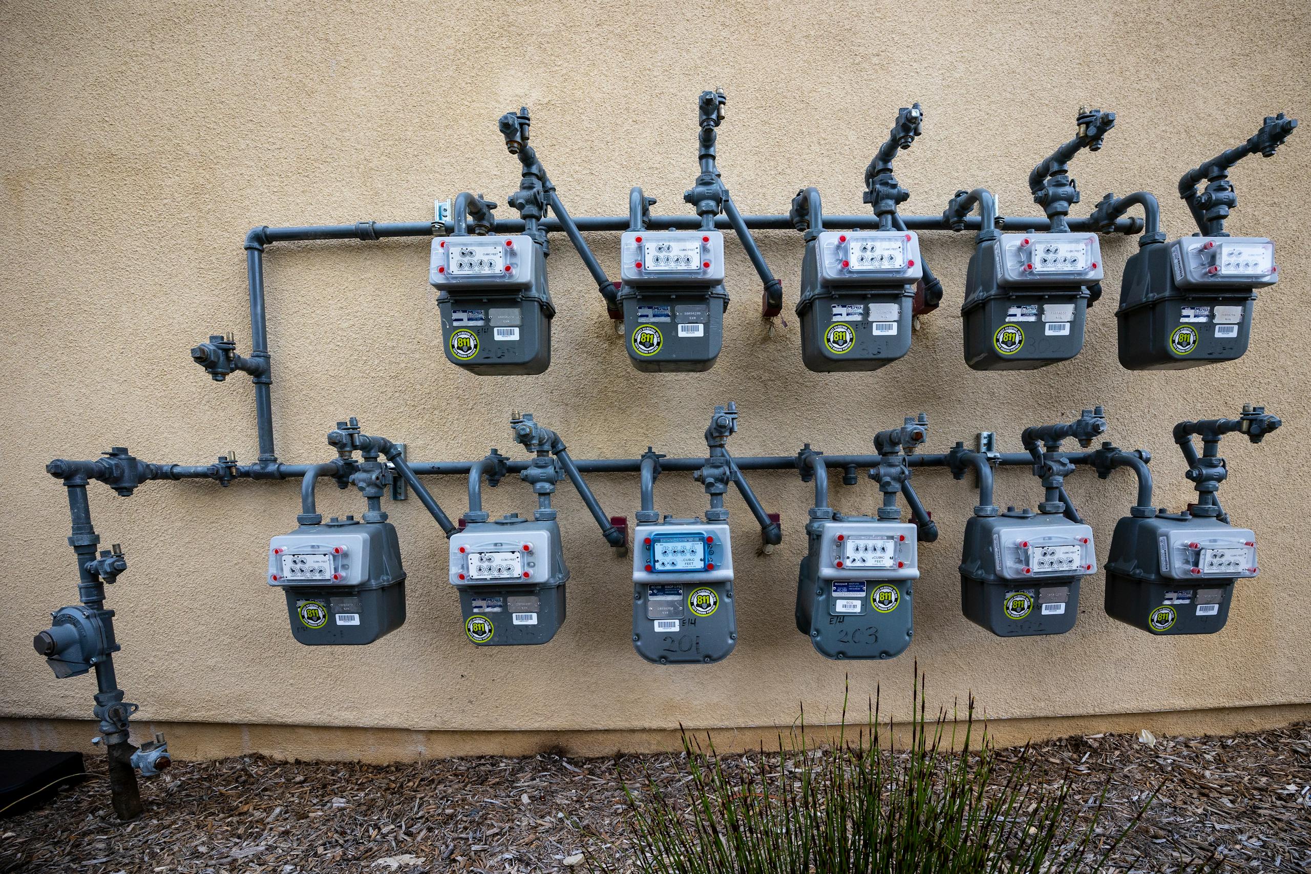 Utilities neat installation of gas meters mounted on an exterior wall in an urban setting.