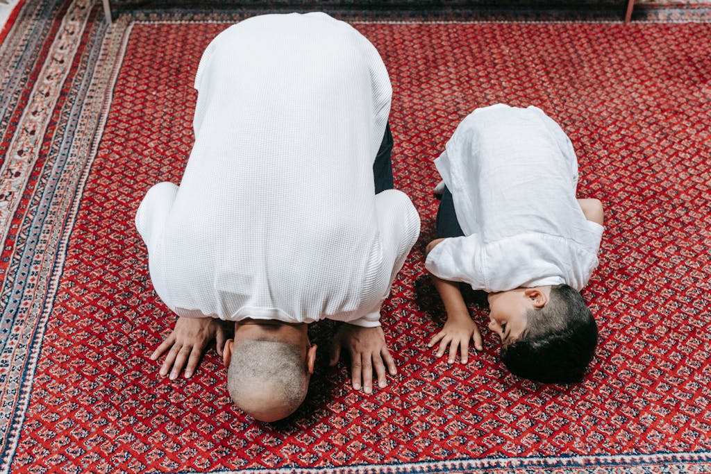 Trios 5 Invisalign Submission A father and son kneeling in prayer on a beautifully patterned red carpet, symbolizing religious devotion.