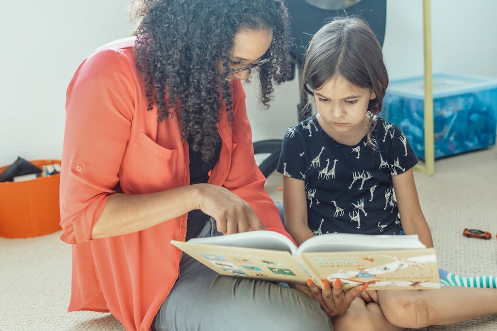 FamousParentingMomlife A mother and daughter share a bonding moment reading a book together at home, fostering love and learning.
