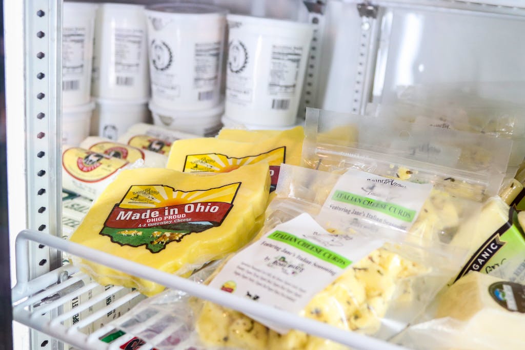 Ohio Champion Trees in Lewis Center, Ohio A variety of fresh Ohio cheeses displayed in a store refrigerator, showcasing local produce.