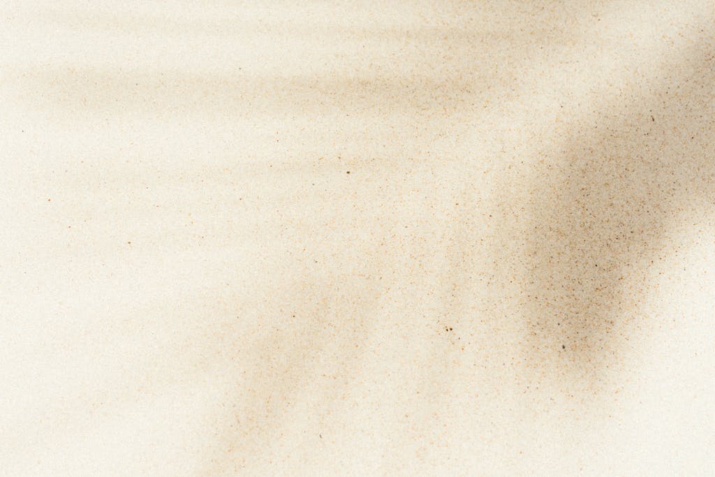 Herbciepscam Artistic sand texture with natural shadows creating a serene abstract pattern, perfect for background use.