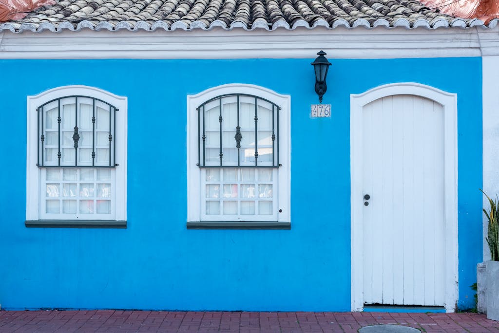 Juntos Seguros ICE Charming blue facade of a house in Porto Seguro, Brazil with traditional windows and door.