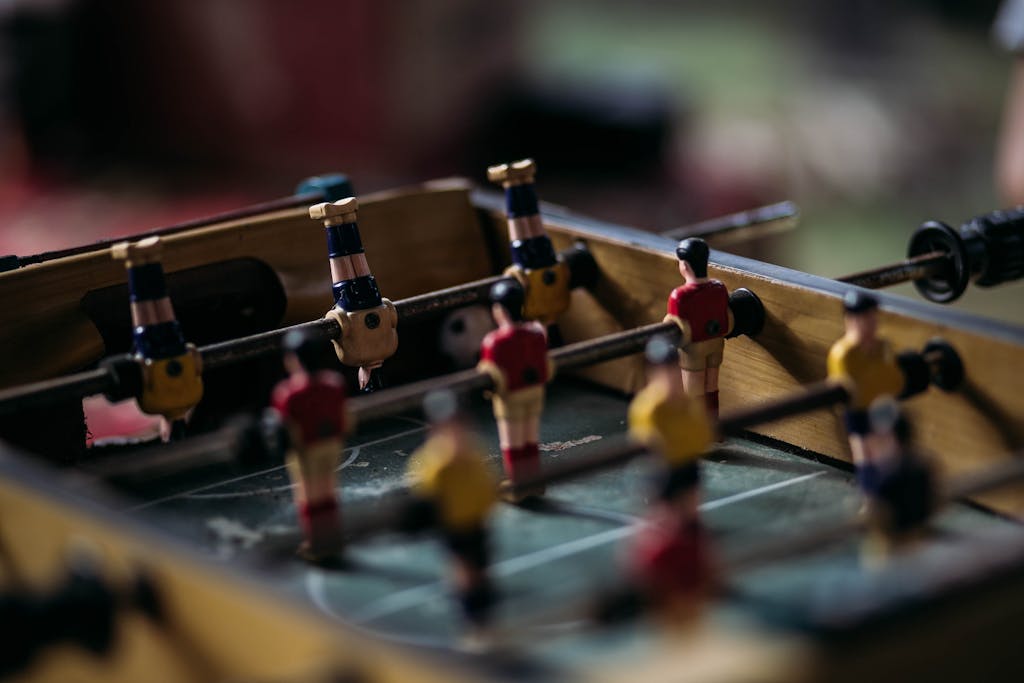 Messeregge Close-up of a foosball table with miniature soccer players in action.