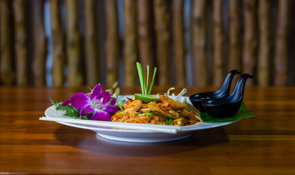 Dampfreis Close-up of a traditional Thai Pad Thai dish with vibrant floral garnishes, exuding a tasty and appetizing look.