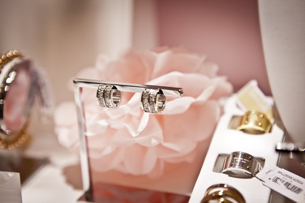 Messeregge Close-up of diamond wedding rings displayed elegantly against a soft pink floral backdrop.