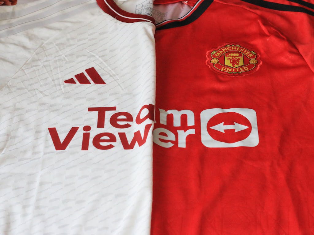 United Flight UA109 Diversion Close-up of Manchester United 2023 jerseys showcasing red and white designs.