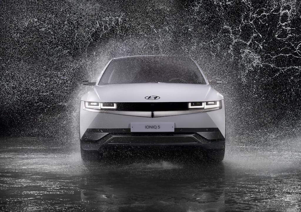 Trios 5 Invisalign Submission Dynamic front view of a Hyundai Ioniq 5 splashing through rain, captured in black and white.