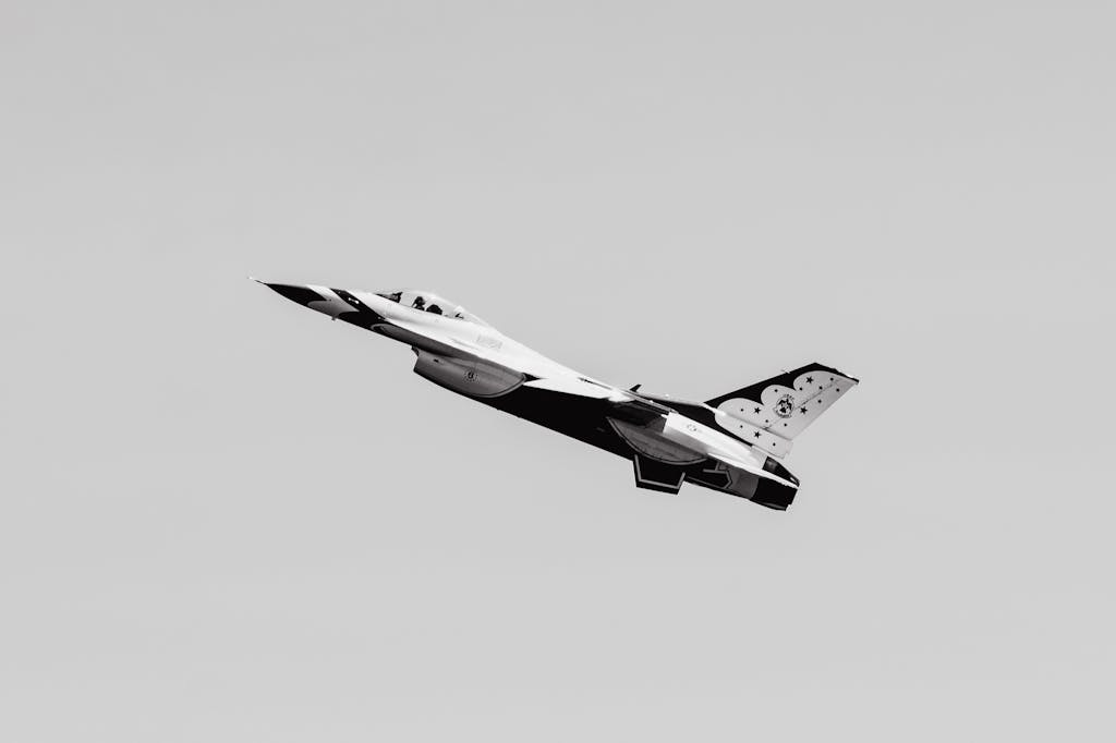 New York Jets  Monochrome image of a military aircraft soaring against a grey sky.