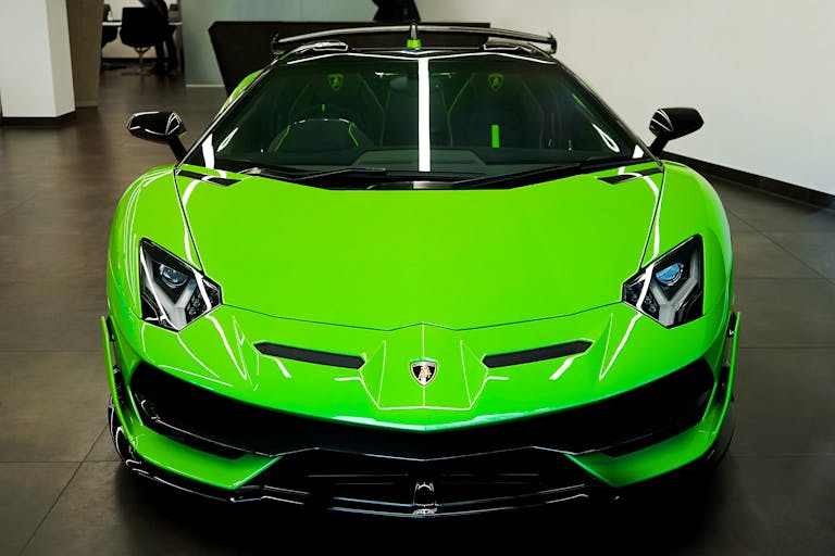 Bottlecrunch Sleek luminous green Lamborghini showcased in an elegant indoor showroom, epitomizing luxury and speed.