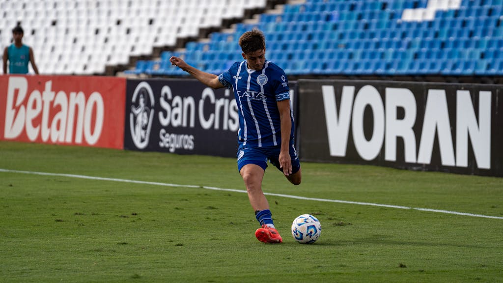Eagles Rookie Trade Attempt Soccer player in blue uniform kicks ball during outdoor match.