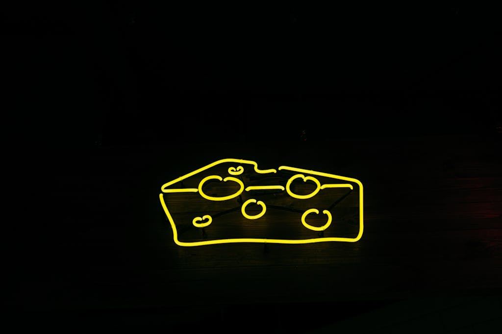 BAC Stock A bright yellow neon sign shaped like cheese against a black background, creating a modern and eye-catching design.